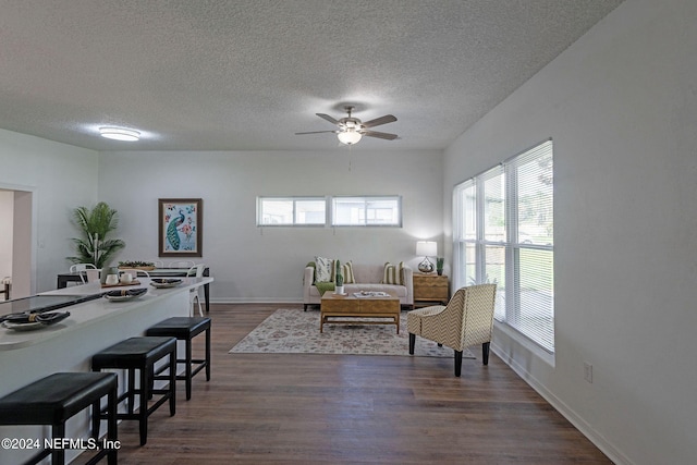 living room with ceiling fan, a textured ceiling, and dark hardwood / wood-style flooring