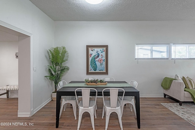 dining room with hardwood / wood-style floors and a textured ceiling