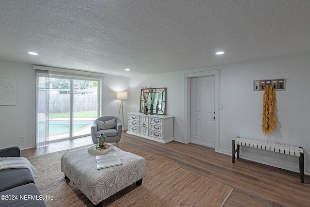 living room featuring a textured ceiling and dark wood-type flooring