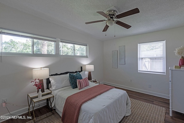 bedroom featuring dark wood-type flooring, ceiling fan, a textured ceiling, and vaulted ceiling