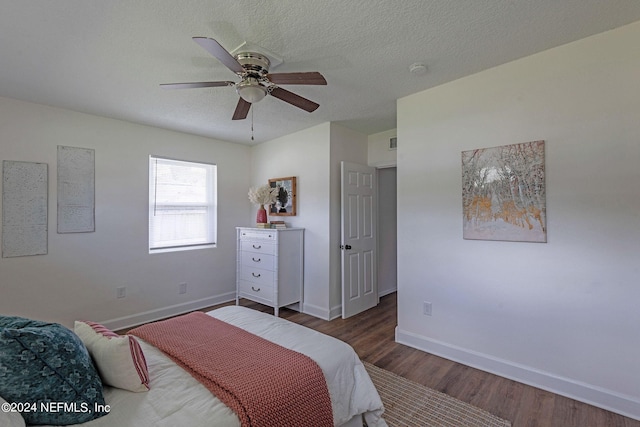 bedroom with dark hardwood / wood-style flooring, a textured ceiling, and ceiling fan