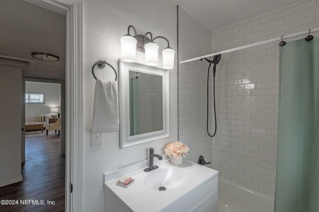 bathroom featuring vanity, hardwood / wood-style floors, shower / bath combination with curtain, and a textured ceiling