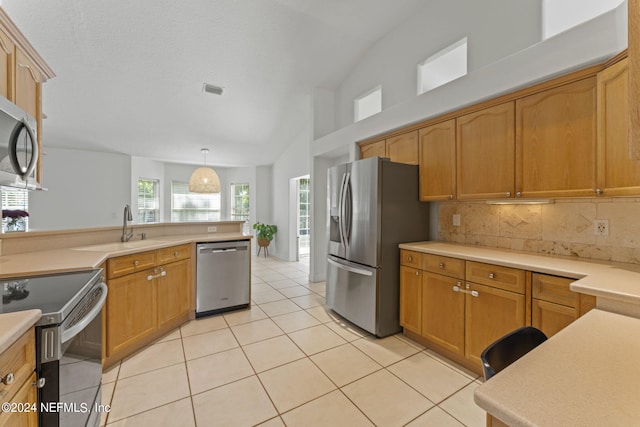 kitchen with stainless steel appliances, light countertops, a sink, and light tile patterned floors