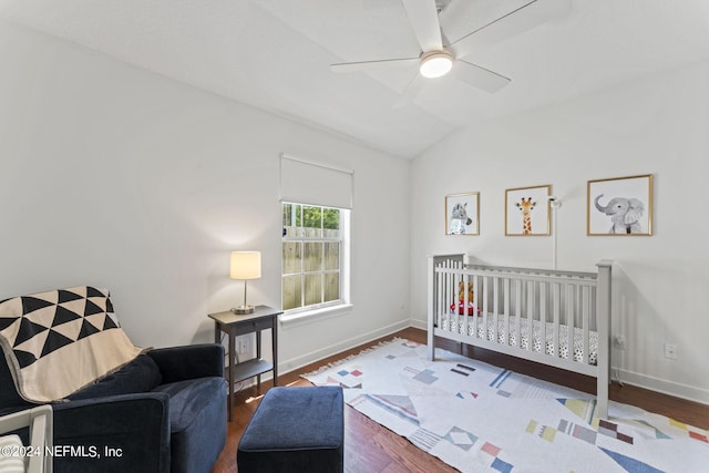 bedroom featuring ceiling fan, vaulted ceiling, baseboards, and wood finished floors