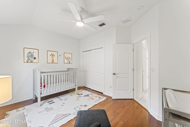 bedroom with a closet, visible vents, ceiling fan, wood finished floors, and baseboards