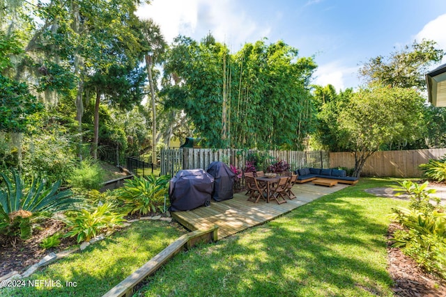 view of yard with a fenced backyard, a wooden deck, and an outdoor living space