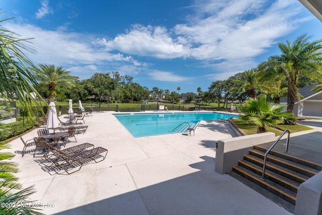 pool with fence and a patio