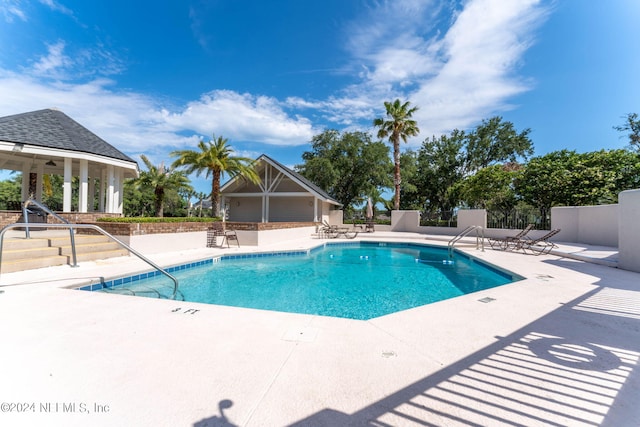 pool featuring a gazebo, a patio area, and fence