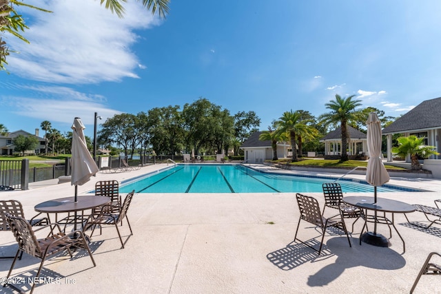 pool featuring fence and a patio