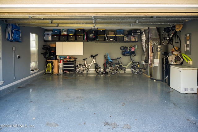 garage with baseboards and electric water heater