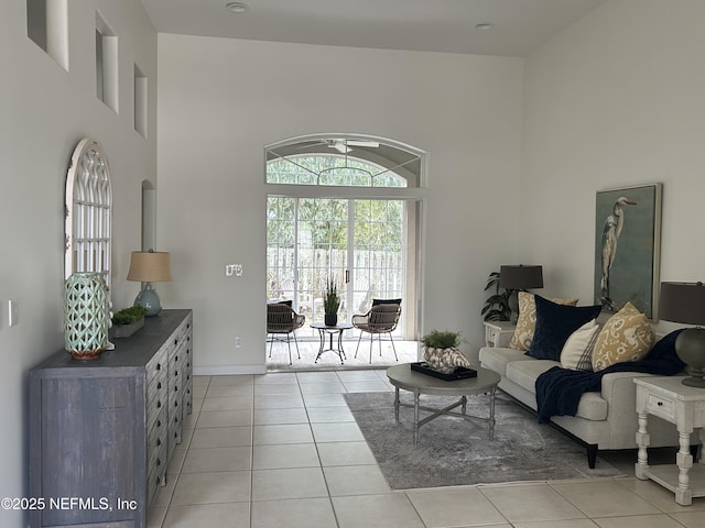 living area with light tile patterned floors and a high ceiling