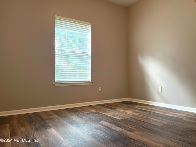 unfurnished room with dark wood-type flooring