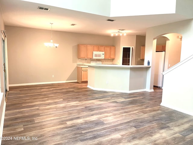 kitchen featuring kitchen peninsula, dark hardwood / wood-style floors, light brown cabinetry, and refrigerator