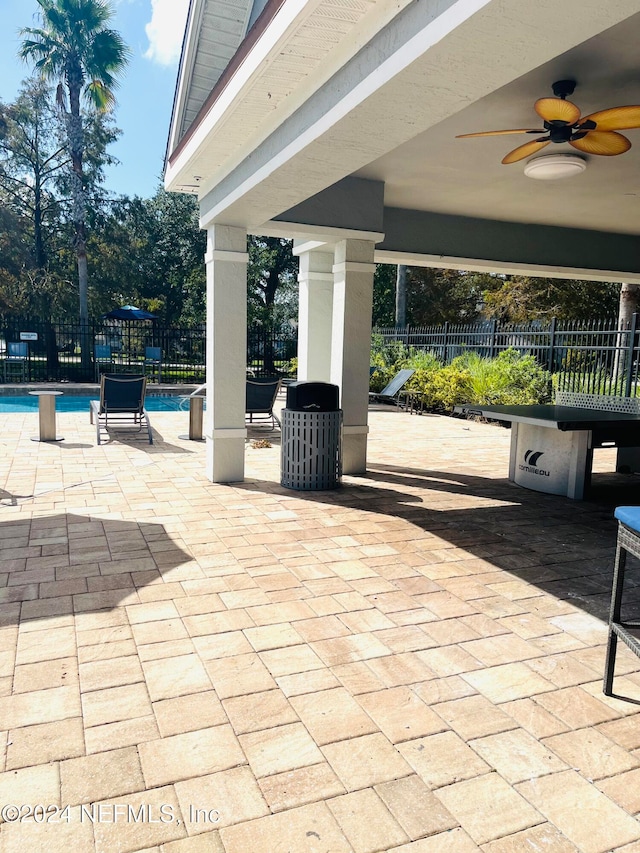 view of patio with ceiling fan and a community pool