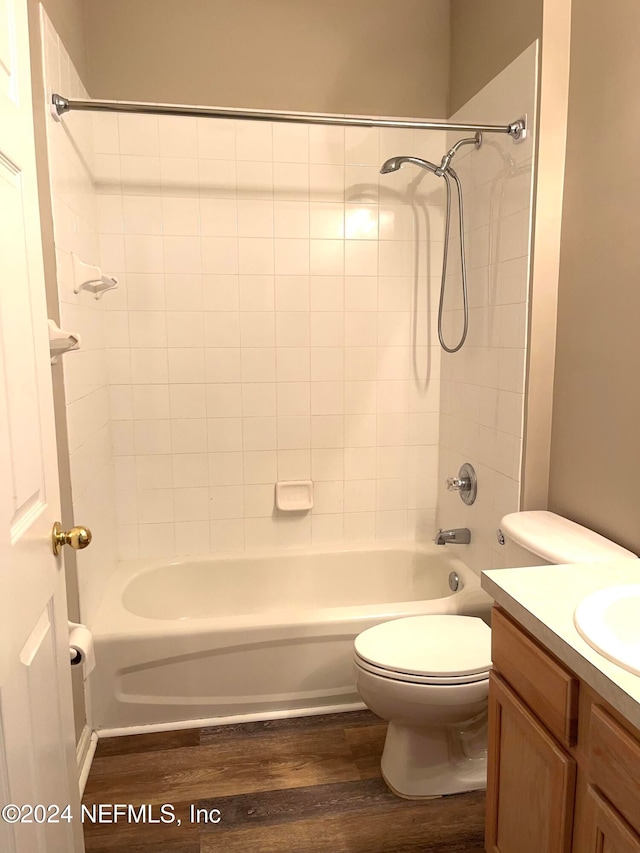 full bathroom with vanity, wood-type flooring, tiled shower / bath, and toilet