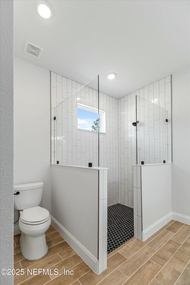 bathroom featuring toilet and tiled shower