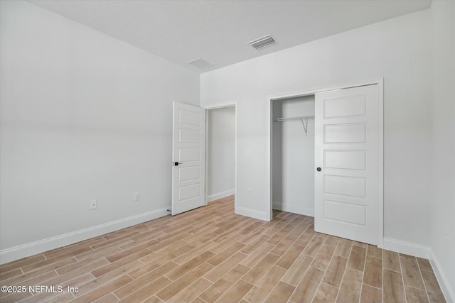 unfurnished bedroom with a closet and light hardwood / wood-style flooring