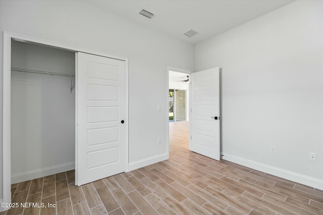 unfurnished bedroom with light wood-type flooring and a closet