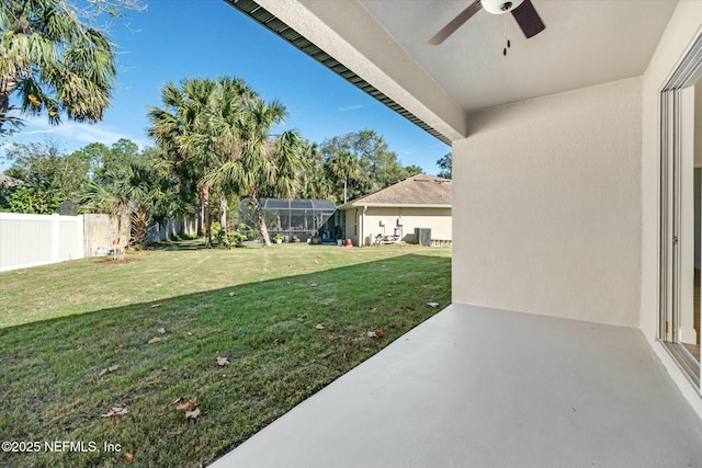 view of yard featuring ceiling fan and a lanai