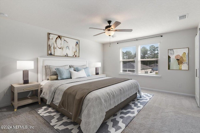 carpeted bedroom with a textured ceiling and ceiling fan