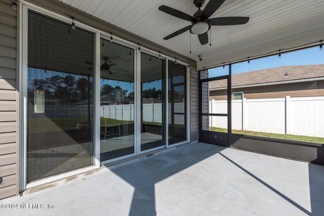 unfurnished sunroom with ceiling fan