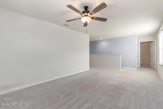 carpeted spare room with ceiling fan