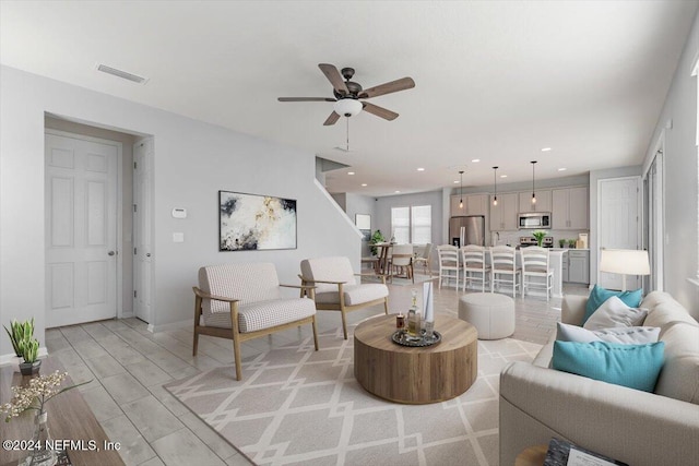 living room featuring ceiling fan and light wood-type flooring