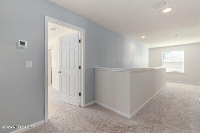 hall with light colored carpet