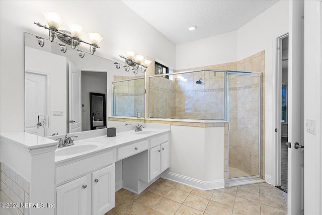 bathroom with tile patterned floors, a textured ceiling, vanity, a shower with door, and a notable chandelier