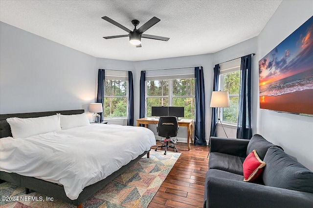 bedroom with a textured ceiling, hardwood / wood-style flooring, and ceiling fan