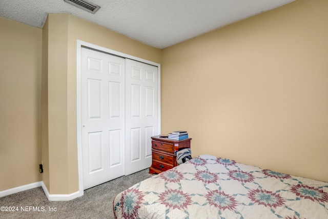 bedroom featuring a textured ceiling, a closet, and carpet