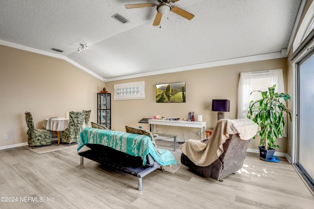 living room with ceiling fan, a textured ceiling, light wood-type flooring, and vaulted ceiling