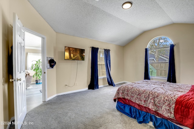 carpeted bedroom featuring a textured ceiling and vaulted ceiling