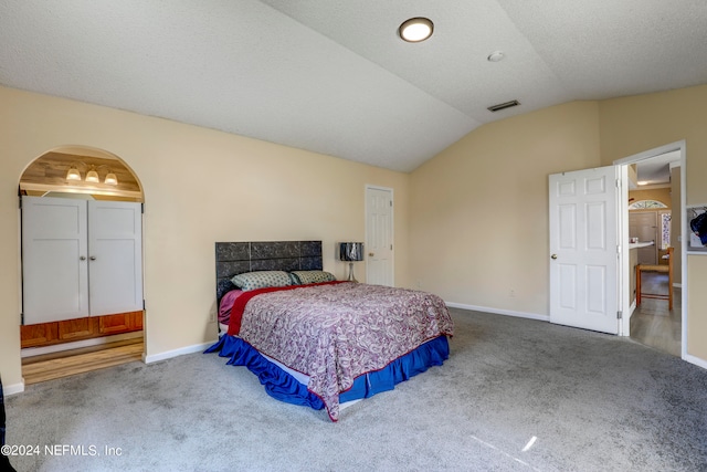 bedroom with vaulted ceiling and carpet