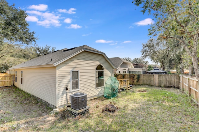 rear view of house with a yard and central AC unit