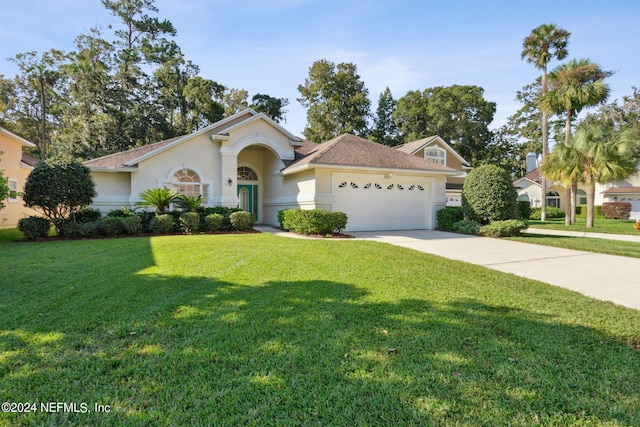 view of front of house featuring a garage and a front lawn