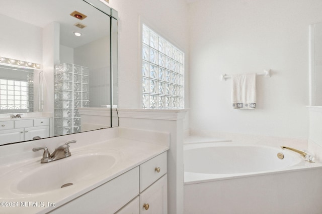 bathroom with vanity and a tub to relax in