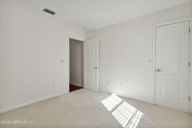 unfurnished room featuring light carpet