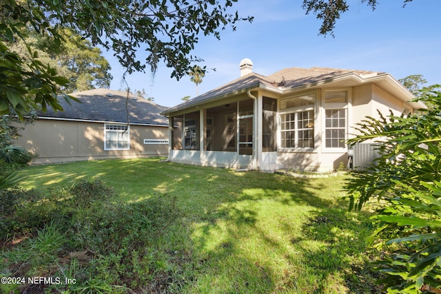 back of house featuring a sunroom and a yard