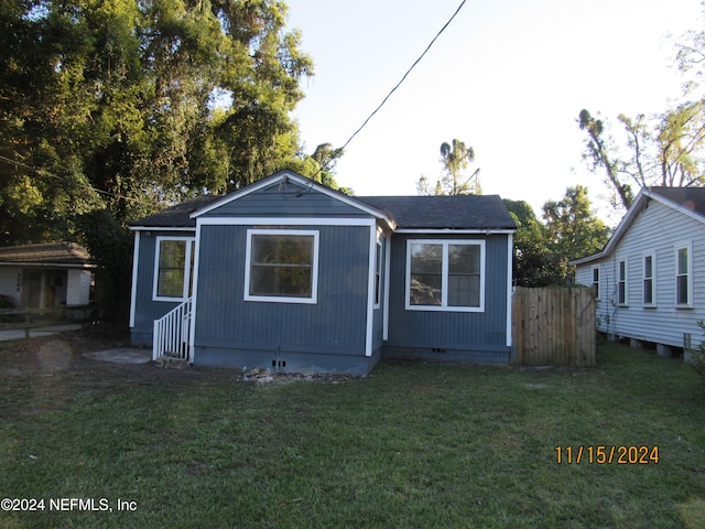 rear view of property featuring a yard