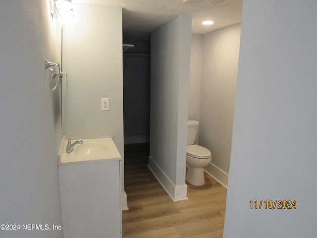 bathroom with vanity, toilet, and wood-type flooring