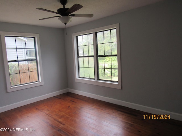 spare room with ceiling fan and dark wood-type flooring