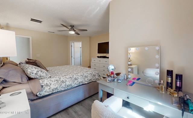 bedroom featuring ceiling fan, a textured ceiling, and light wood-type flooring