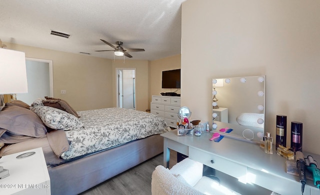 bedroom with wood finished floors, ceiling fan, and a textured ceiling