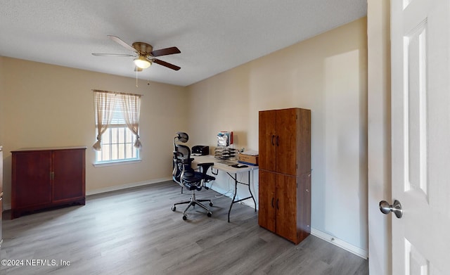 office space with wood finished floors, ceiling fan, a textured ceiling, and baseboards