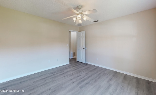 empty room featuring light hardwood / wood-style flooring, a textured ceiling, and ceiling fan