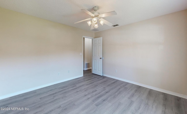 empty room with wood finished floors, baseboards, and a ceiling fan