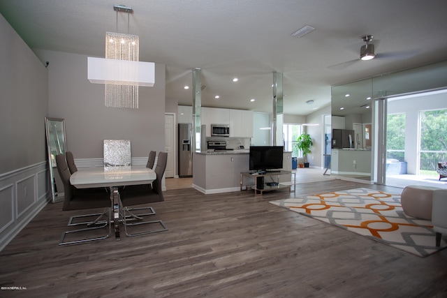 dining space featuring dark hardwood / wood-style floors, ceiling fan, and vaulted ceiling