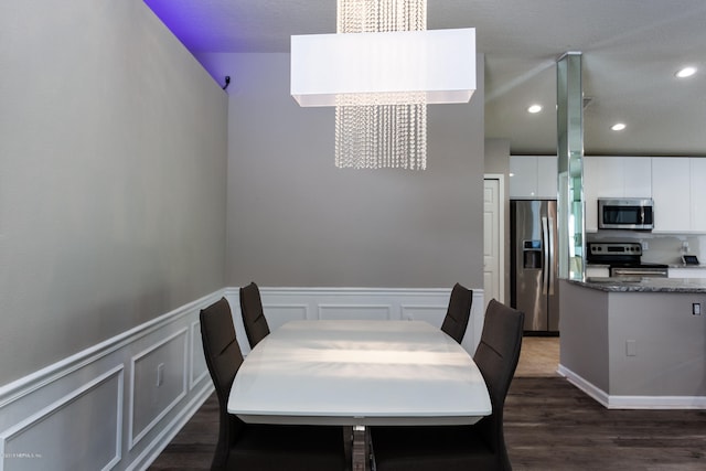 dining area featuring dark hardwood / wood-style flooring and a chandelier