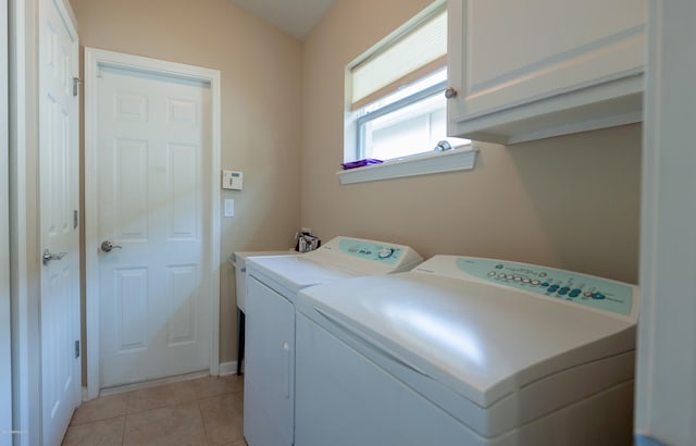 washroom with washer and clothes dryer, cabinets, and light tile patterned floors